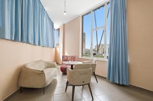 a living room with chairs and a table and windows at The Cliff Suites in Golem