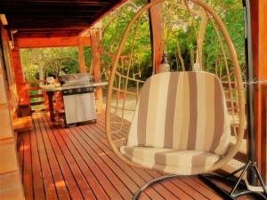 einen Schaukelstuhl auf einer Veranda mit Grill in der Unterkunft YOISAMA Sunrise Beach House in Ishigaki-jima