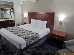 a hotel room with a large bed and a chair at Best Western Montis Inn in Saint Robert +4 photos