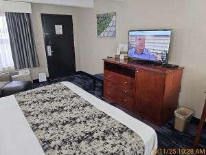 a hotel room with a bed and a flat screen tv at Best Western Montis Inn in Saint Robert