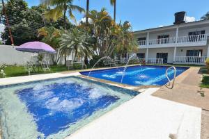 a swimming pool in front of a house at Hotel terranova in Melgar