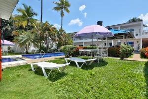 two tables and an umbrella next to a pool at Hotel terranova in Melgar