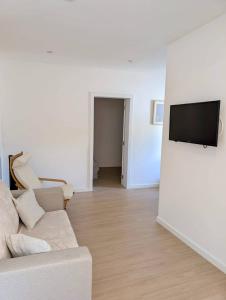 a living room with a couch and a flat screen tv at Casa do Picadeiro in Elvas