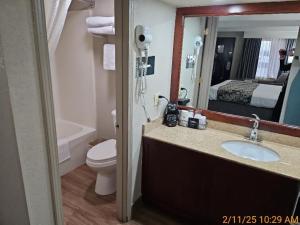 a bathroom with a sink and a toilet and a mirror at Best Western Montis Inn in Saint Robert