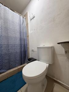 a bathroom with a white toilet and a shower at Tico-living in Alajuela