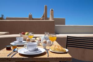 una mesa con desayuno y bebidas en el balcón en Voreina Gallery Suites en Pyrgos