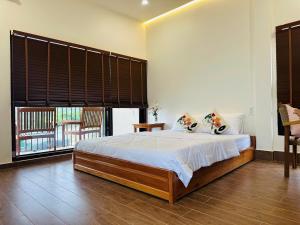 a bedroom with a bed and a large window at Núp Gió Cottages in Ấp Mỹ Hải +77 photos