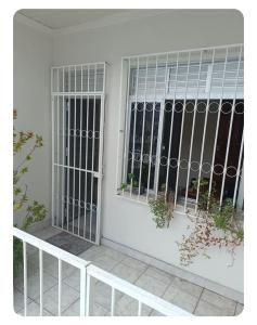 a white door with barred windows on a house at Simplicidade e localização privilegiada no coração de Adrianópolis em Manaus in Manaus