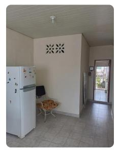 a kitchen with a white refrigerator and a chair at Simplicidade e localização privilegiada no coração de Adrianópolis em Manaus in Manaus