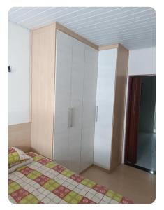 a bedroom with a bed and white cabinets at Simplicidade e localização privilegiada no coração de Adrianópolis em Manaus in Manaus