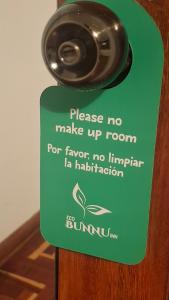 a green sign that says please no make up room for fewer than no immigrant la at Eco Bunnu Inn Santa Ana in Cusco