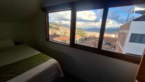 a room with a window with a view of a city at Eco Bunnu Inn Santa Ana in Cusco