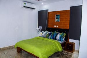 a bedroom with a bed with a green comforter at villa km19 in Assinie
