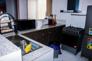 a kitchen with a sink and a stove at villa km19 in Assinie +2 photos