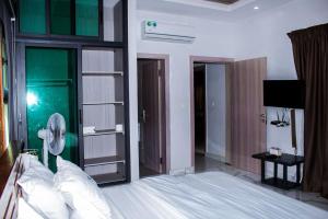 a bedroom with a large bed and a fan at villa km19 in Assinie