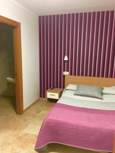 a bedroom with a bed and a purple curtain at Hostal La Cortijana in Logroño
