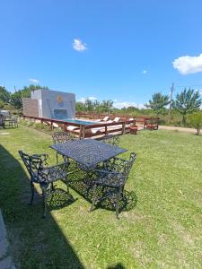 ein Picknicktisch und Stühle auf einem Rasenfeld in der Unterkunft SUEÑOS DE TERMAS in Chajarí