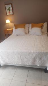 a large bed in a bedroom next to a table at Barrio Aeropuerto 1 in RSA +11 photos