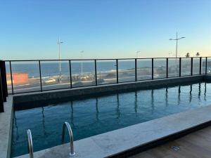 a swimming pool with a view of the ocean at Studio nascente na Pituba in Salvador