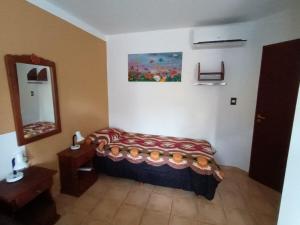 a small bedroom with a bed and a mirror at Departamento CRIMAR in Viedma