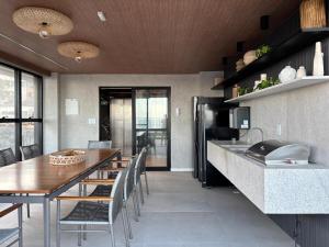 a kitchen with a table and chairs and a refrigerator at Studio nascente na Pituba in Salvador