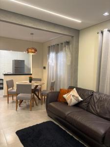 a living room with a couch and a table at Casa Nova, 2 quartos, 1 Ar-Cond, 1 Banheiro, Garagem 4,30m in Montes Claros