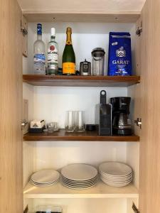 a pantry with plates and bottles of wine and alcohol at Apartment near Azteca Stadium- Coyoacan in Mexico City