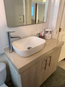 a bathroom with a white sink and a toilet at Apartment near Azteca Stadium- Coyoacan in Mexico City
