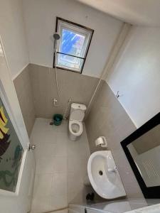 a small bathroom with a toilet and a window at Poseidon White Sand Resort & Cave in Santa Rosa