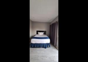 a bedroom with a bed with a blue and white blanket at Rainbow Motel in Summit
