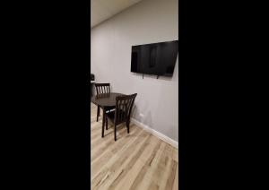 a dining room with a table and a television on a wall at Rainbow Motel in Summit