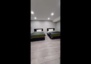 two beds in a room with wooden floors at Rainbow Motel in Summit +1 photo