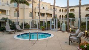 a pool in a courtyard with chairs and a building at Hidden Coastal Gem Between Malibu & SB in Oxnard