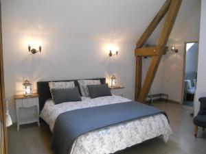 a bedroom with a large bed and two night stands at Les Mille et une Pierres in Mareuil-le-Port