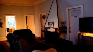 a living room with a couch and a television at Vila Santa Eulália Hostel in Pelotas