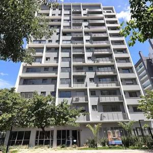 a tall white apartment building with trees in front of it at MOOD Modern Studio, Central Parque in Porto Alegre