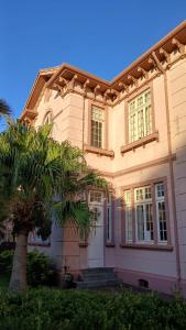 a house with a palm tree in front of it at Vila Santa Eulália Hostel in Pelotas