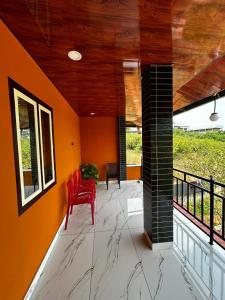 a room with a red chair on a balcony at brothers holidayas vagamon in Vagamon