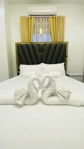 a bed with two infinity towels on it at Mira Transient in Bantay +3 photos