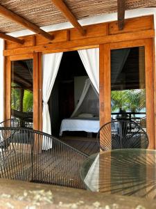a patio with a bed and a table with a glass table at Bungalos Blanca in Temalhuacán