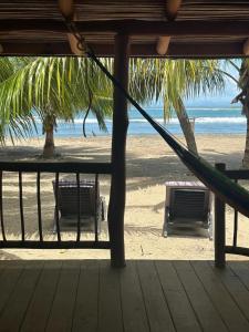 a hammock on a beach with a view of the ocean at Bungalos Blanca in Temalhuacán