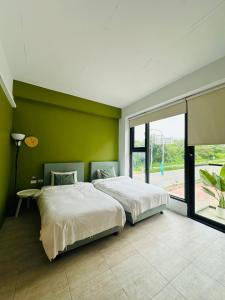 a bedroom with two beds and a green wall at 依山村驛Yishan Village in Jincheng +213 photos