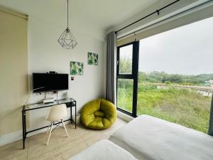 a bedroom with a bed and a desk and a window at 依山村驛Yishan Village in Jincheng