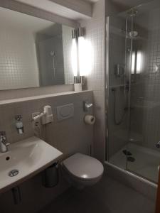 La salle de bains est pourvue de toilettes, d'une douche et d'un lavabo. dans l'établissement Tagungshaus Himmelspforten - Self Check-In, à Wurtzbourg