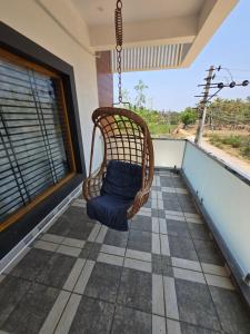 a porch with a swinging chair on a balcony at Dsouza Stay in Mysore