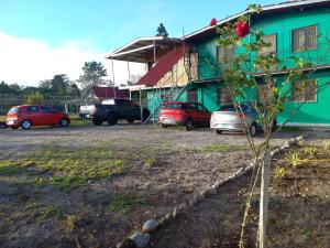 a tree in front of a building with parked cars at Volcán Barú Unique Studio Apartment in Nueva California