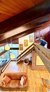 a living room with a couch and a person in a room at Lake front, Mid-century house with sauna 2 in Budgewoi