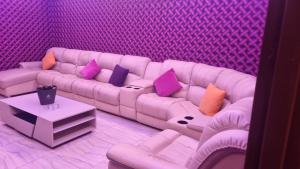 a living room with a white couch with purple pillows at SriStar in Kluang +3 photos