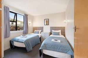 a bedroom with two beds and a window at Oakleigh Motel in Gore