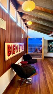 a living room with two chairs and a tv at Lake front, Mid-century house with sauna 2 in Budgewoi